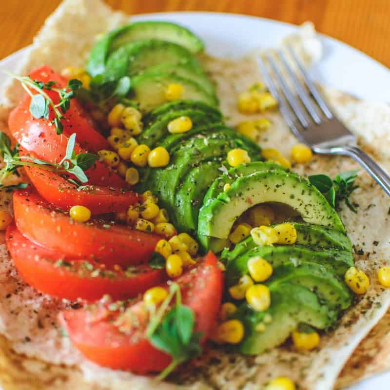 Salada de tomate com abacate picado e um pouco de milho.